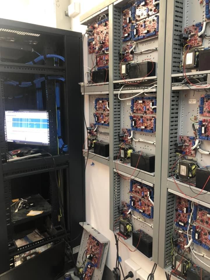 Yellow electrical tester measuring voltage at an outdoor outlet; a hand holds the device.