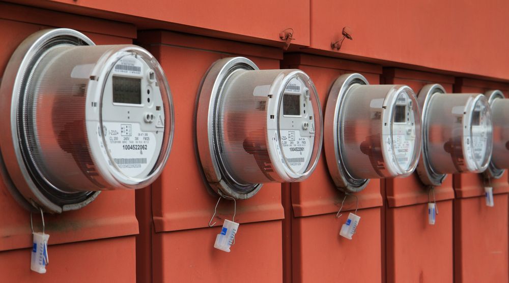 Row of Silver Digital Electric Meters on a Red Wall — EBS NQ Electronic Building Systems in Kirwan, QLD