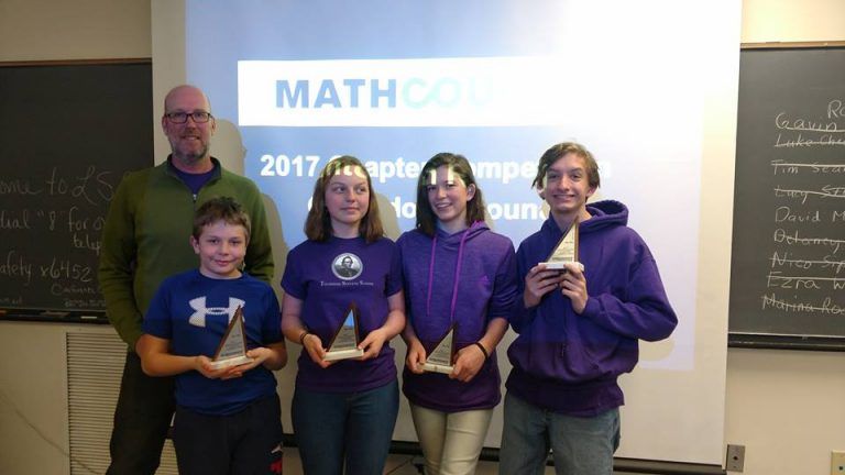mathcounts competition team and coach standing with awards