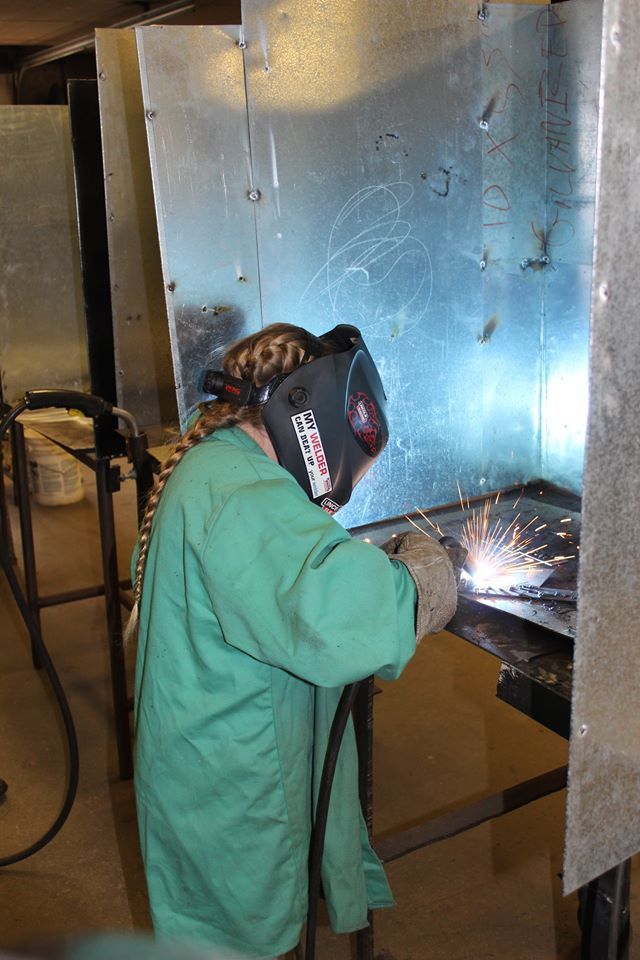girl wearing a mask welding metal