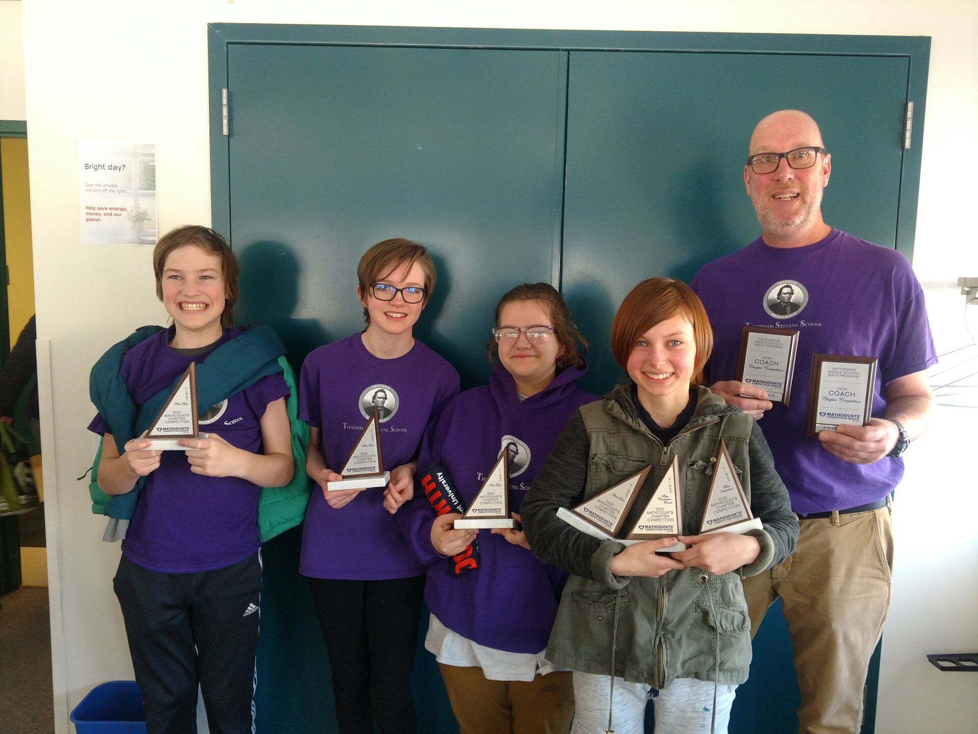 mathcounts competition team and coach standing with awards
