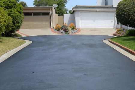 A driveway leading to a house with a garage.