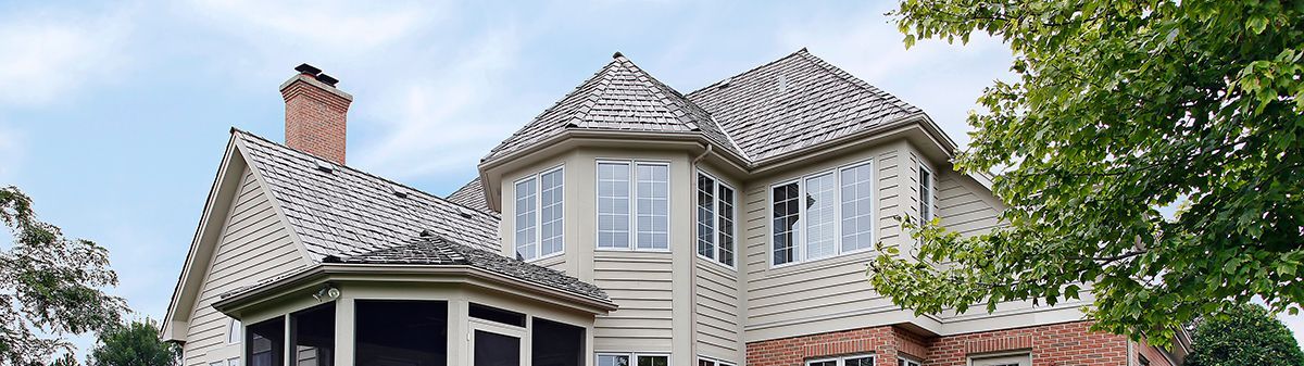A stone chimney is sitting on top of a roof.