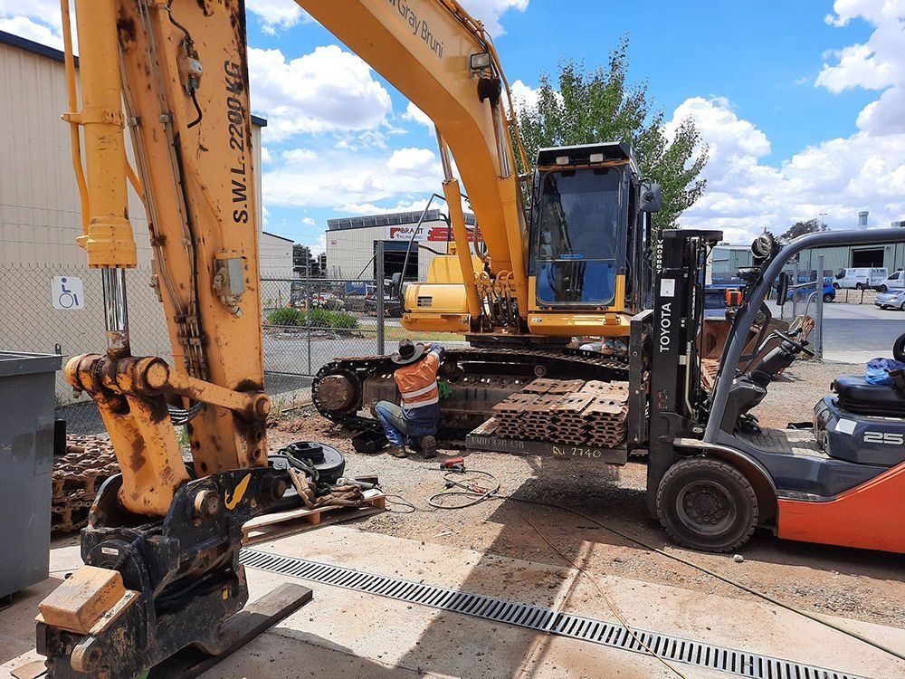 Forklift Supporting Excavator Track While Worker Repairs It — Wyatt Mechanical Pty Ltd In Wodonga, VIC