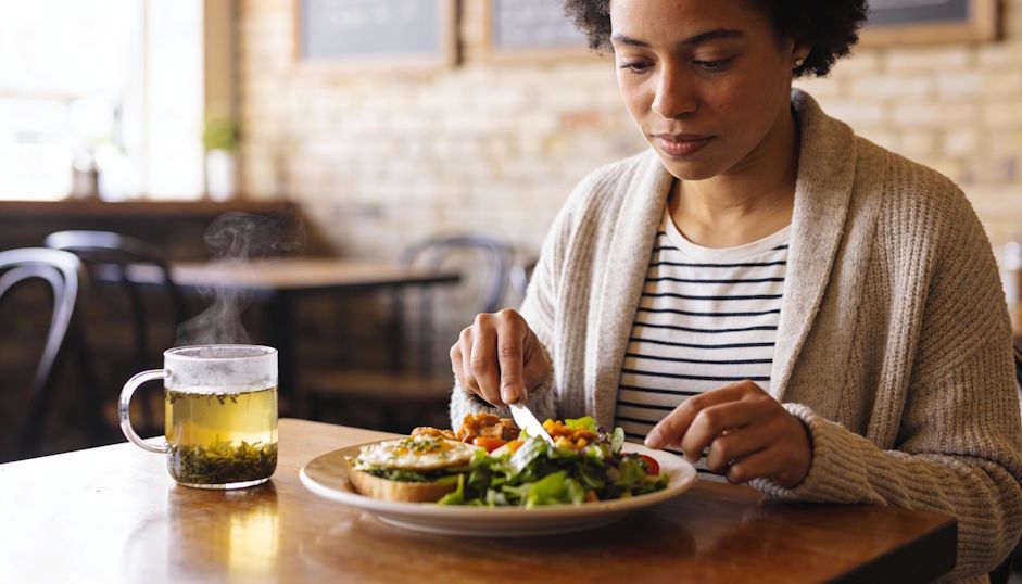 Dayton woman eating a healthy meal at a local café calm confidence steaming herbal tea on table