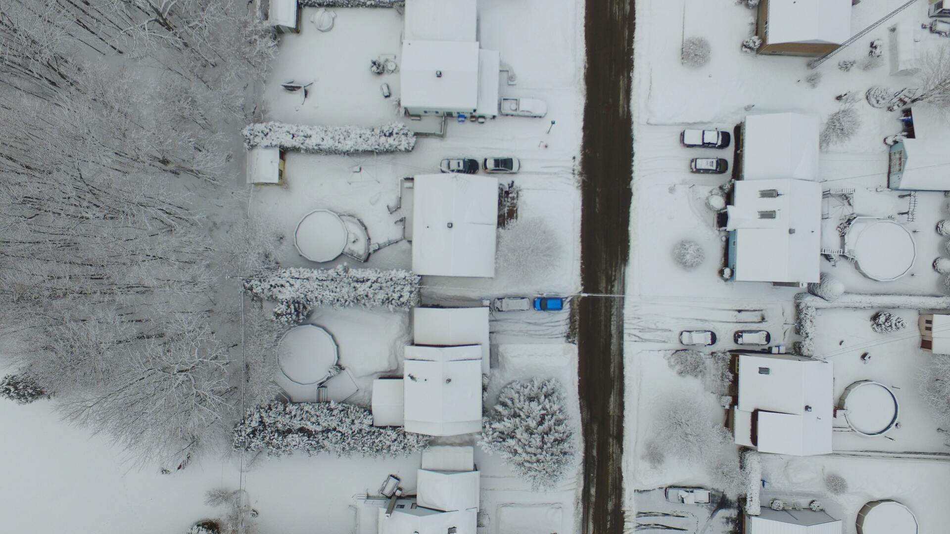 An aerial view of a residential area covered in snow.
