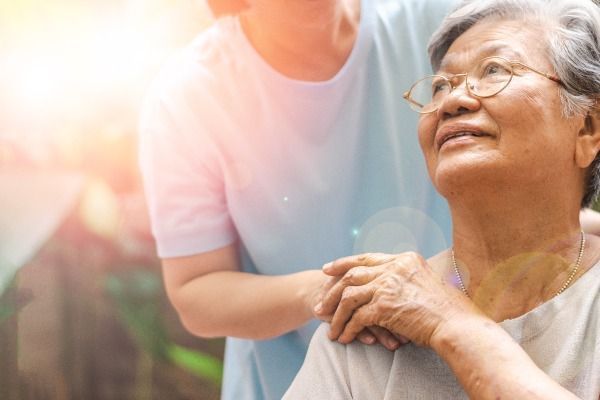 an elderly woman in a wheelchair is being helped by a nurse .
