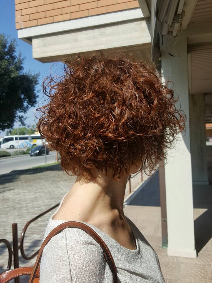 donna con capelli rossi ricci e taglio corto