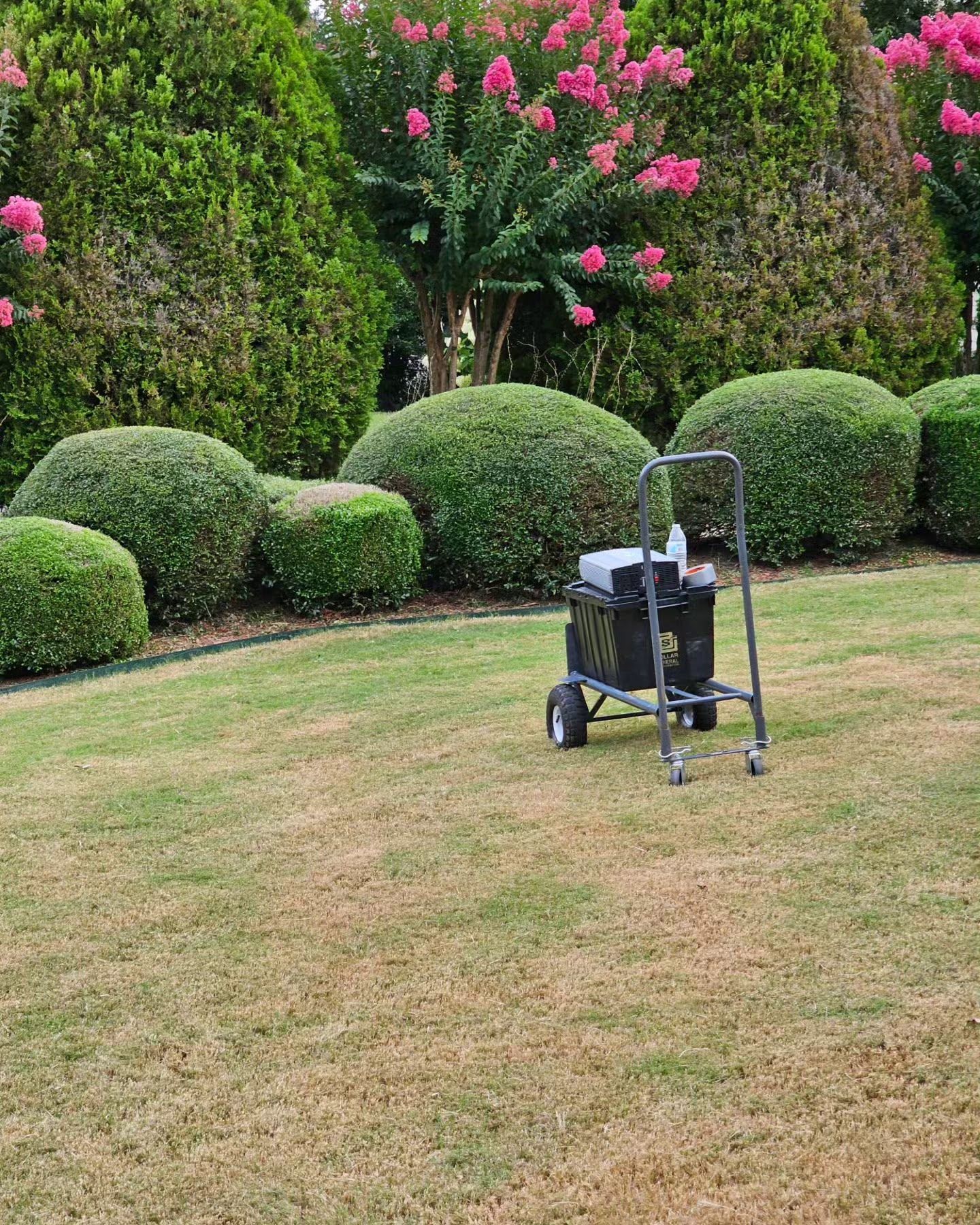 A lawn mower is sitting in the middle of a lush green lawn.