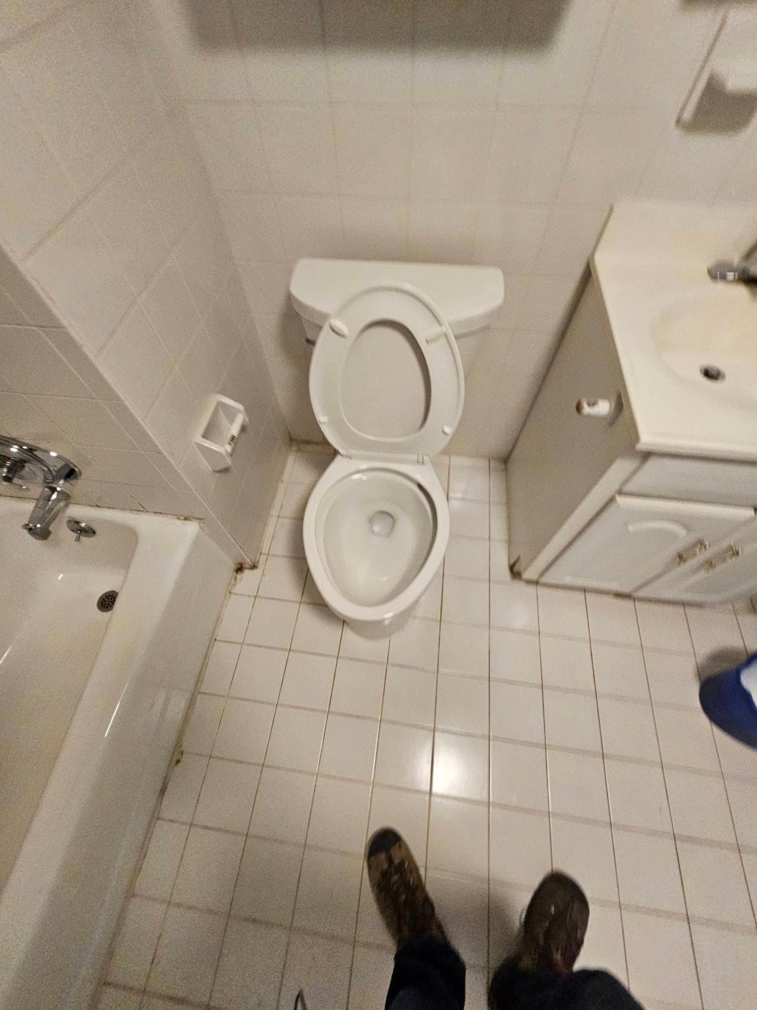 A bathroom with a toilet , sink and bathtub.