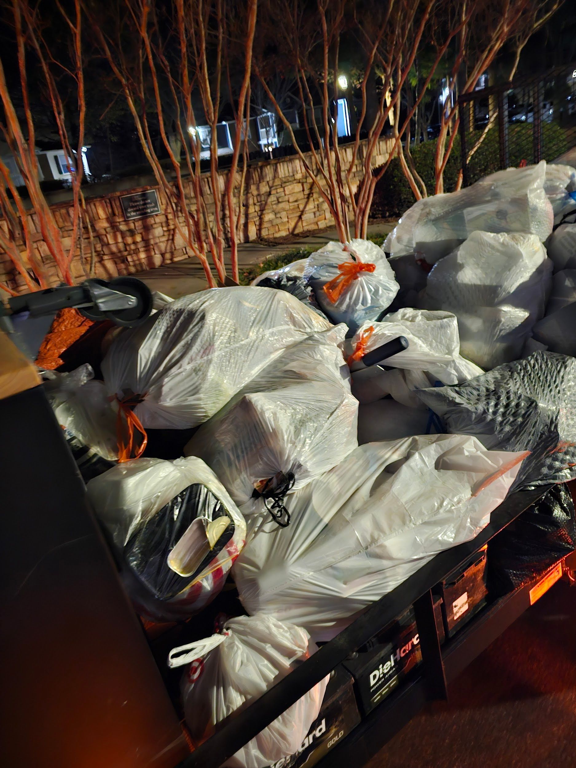 A truck is filled with lots of plastic bags at night.