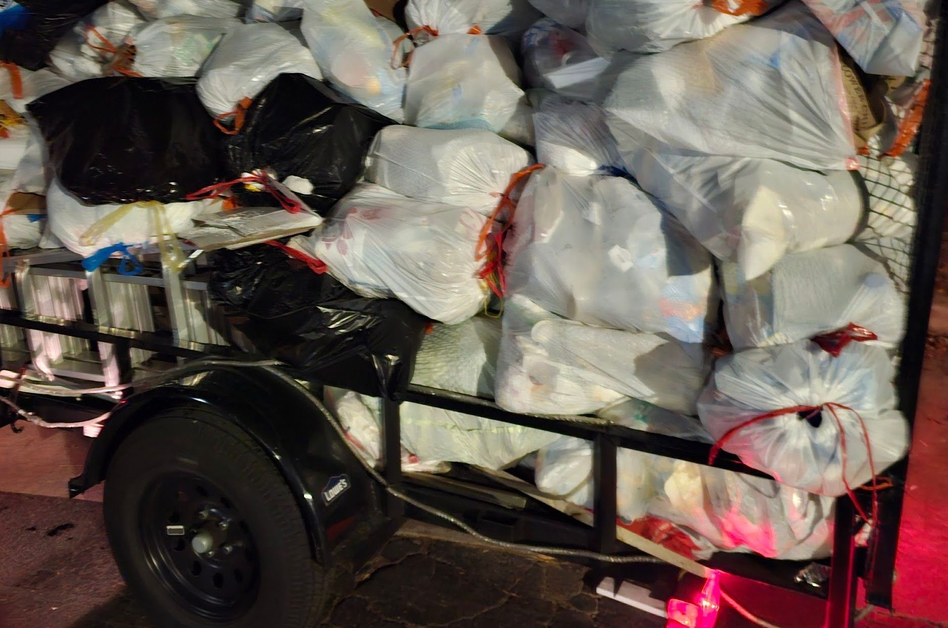 A trailer is full of trash bags and boxes