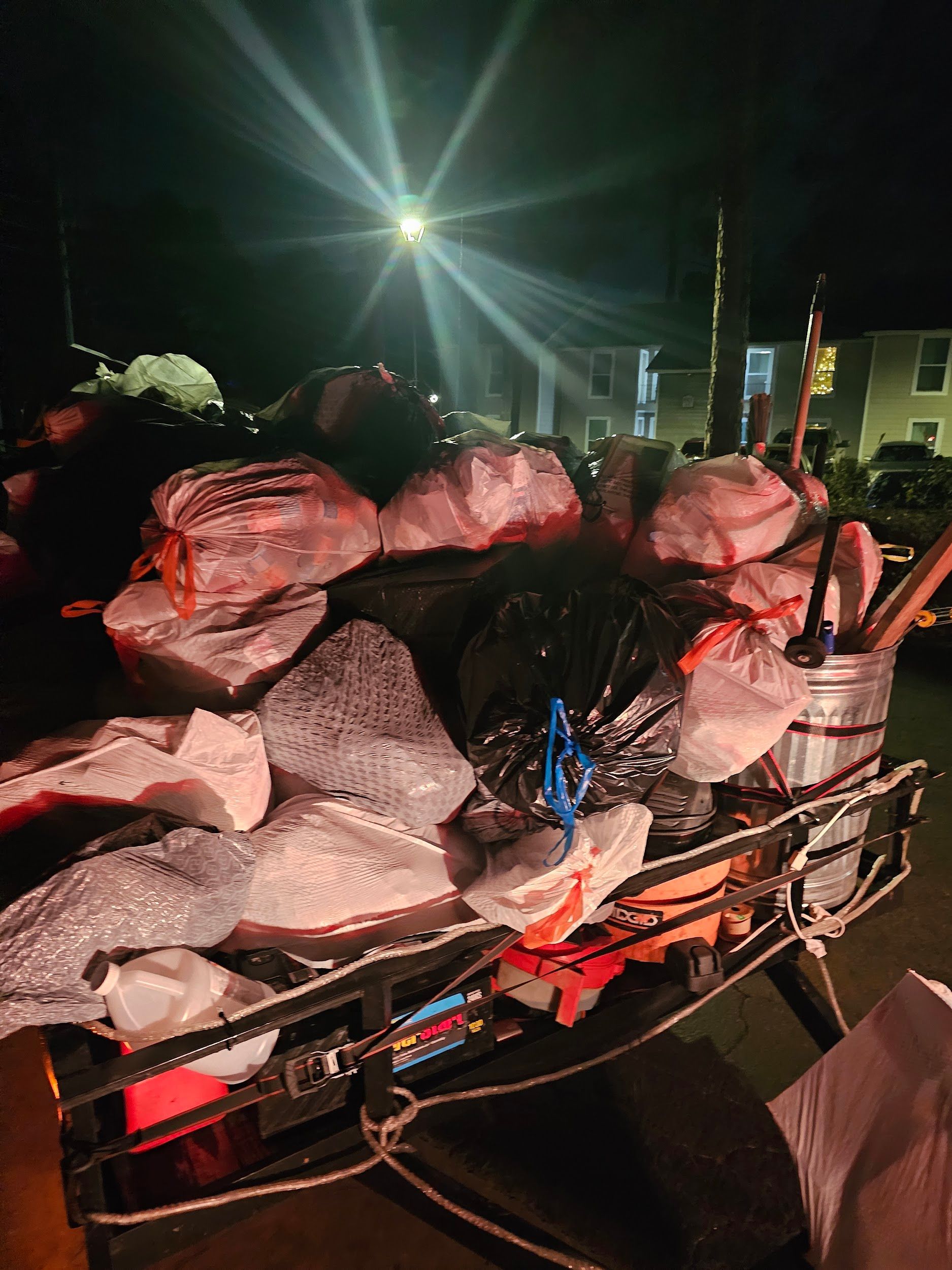 A pile of meat is on the back of a truck at night.
