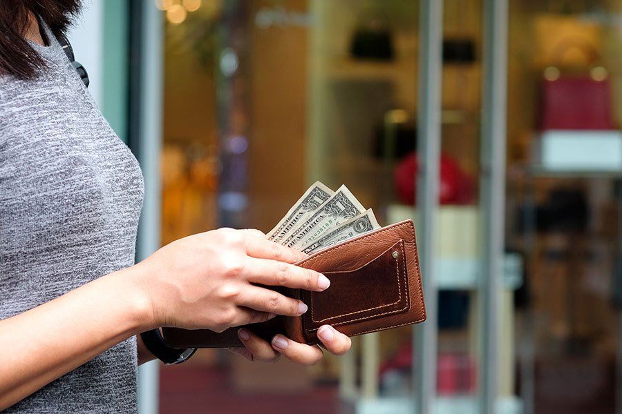 A woman is taking money out of her wallet.