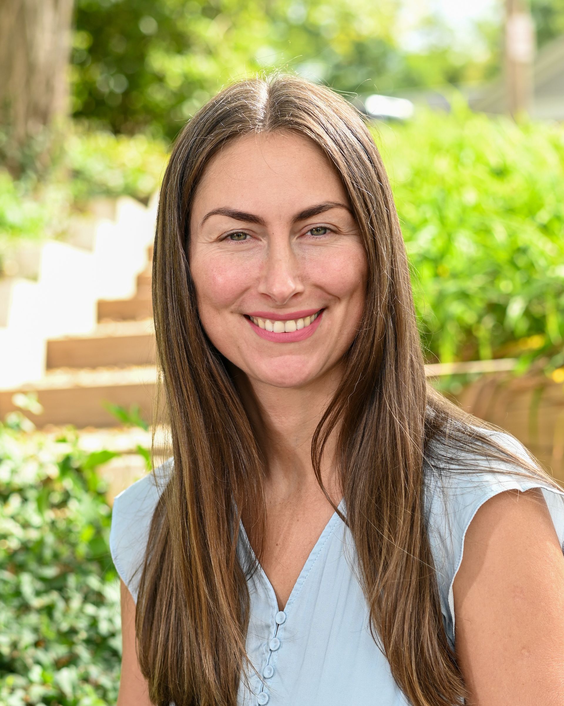 A woman with long hair is smiling in a circle.