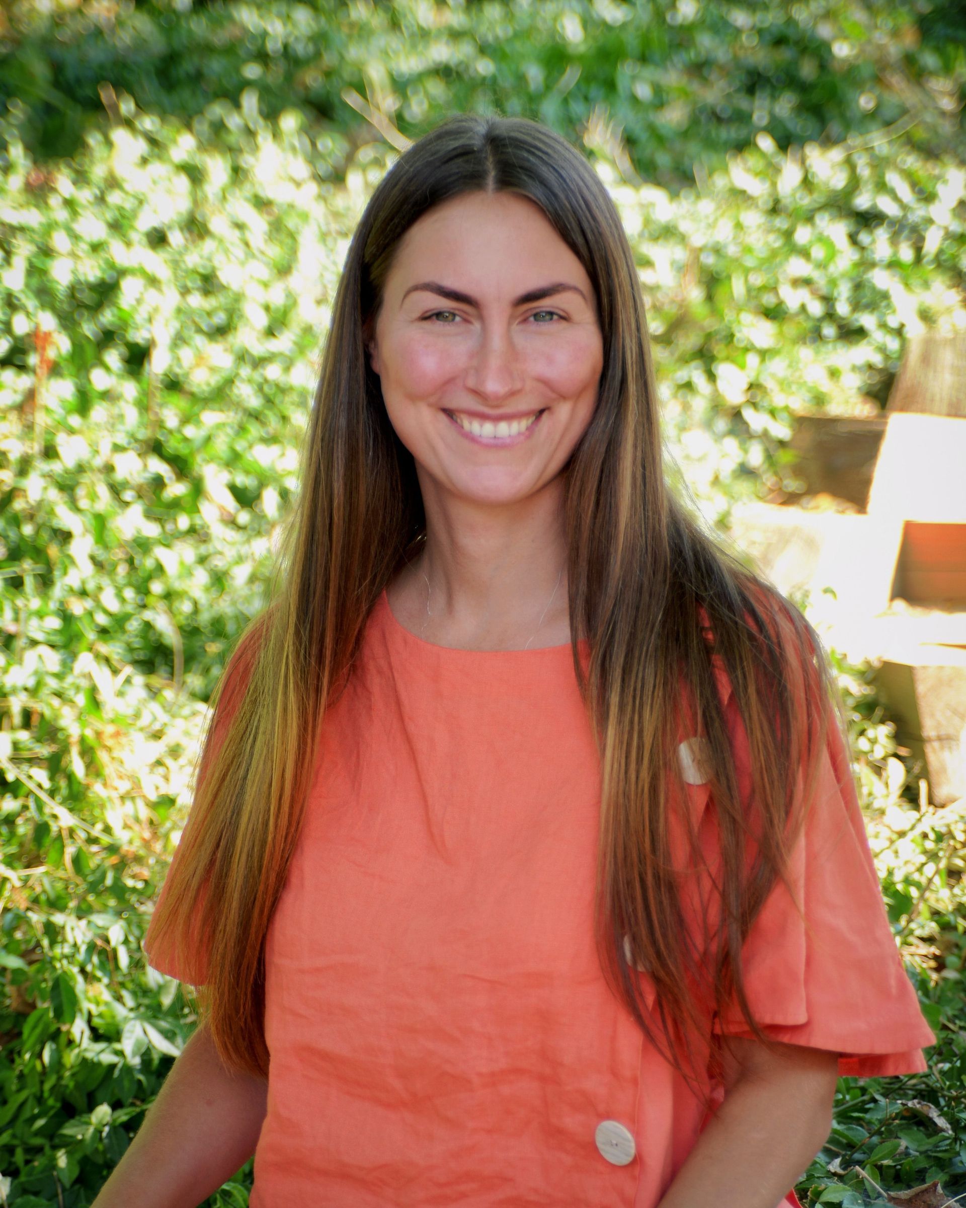 A woman with long hair is smiling in a circle.