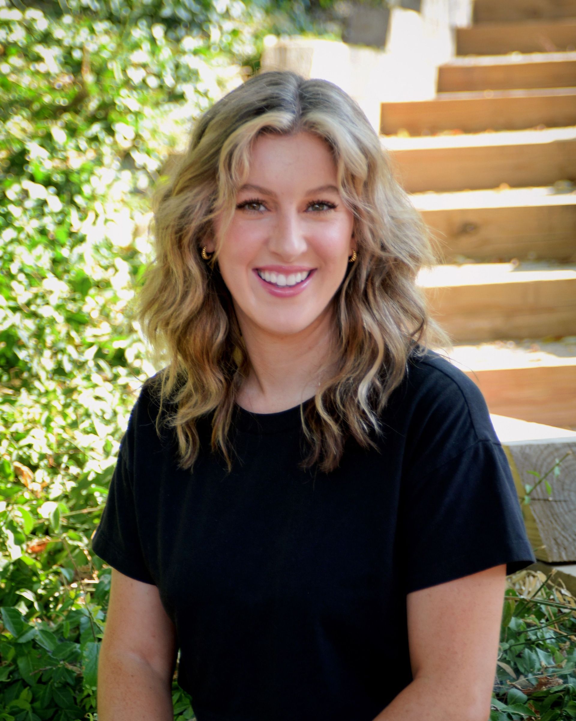 A woman in a blue shirt is smiling for the camera