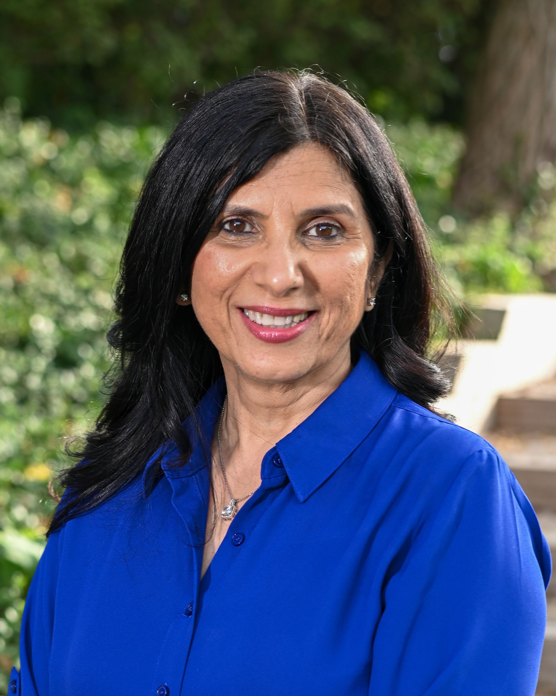 A woman in a plaid shirt is smiling in a circle.