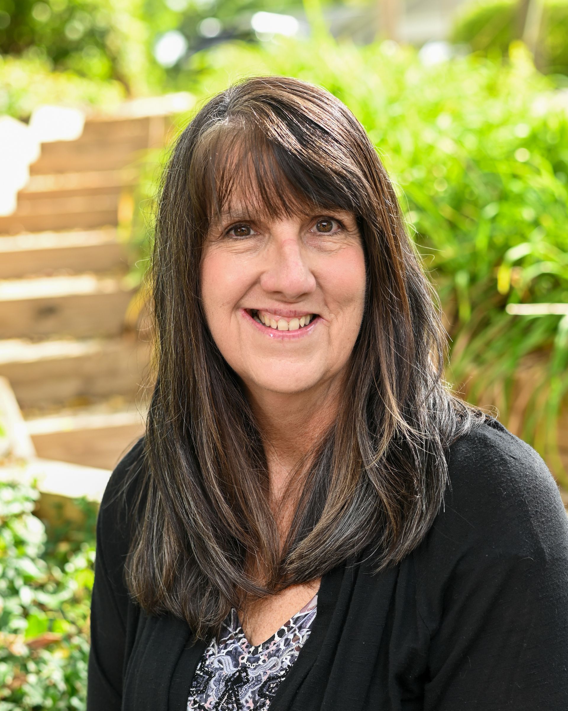 A woman in a blue shirt is smiling for the camera