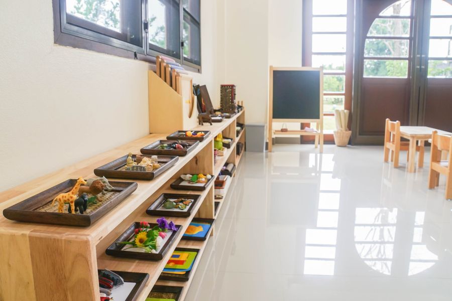 A classroom with a lot of shelves and toys on them.