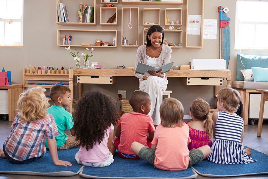 A teacher is reading a book to a group of children.