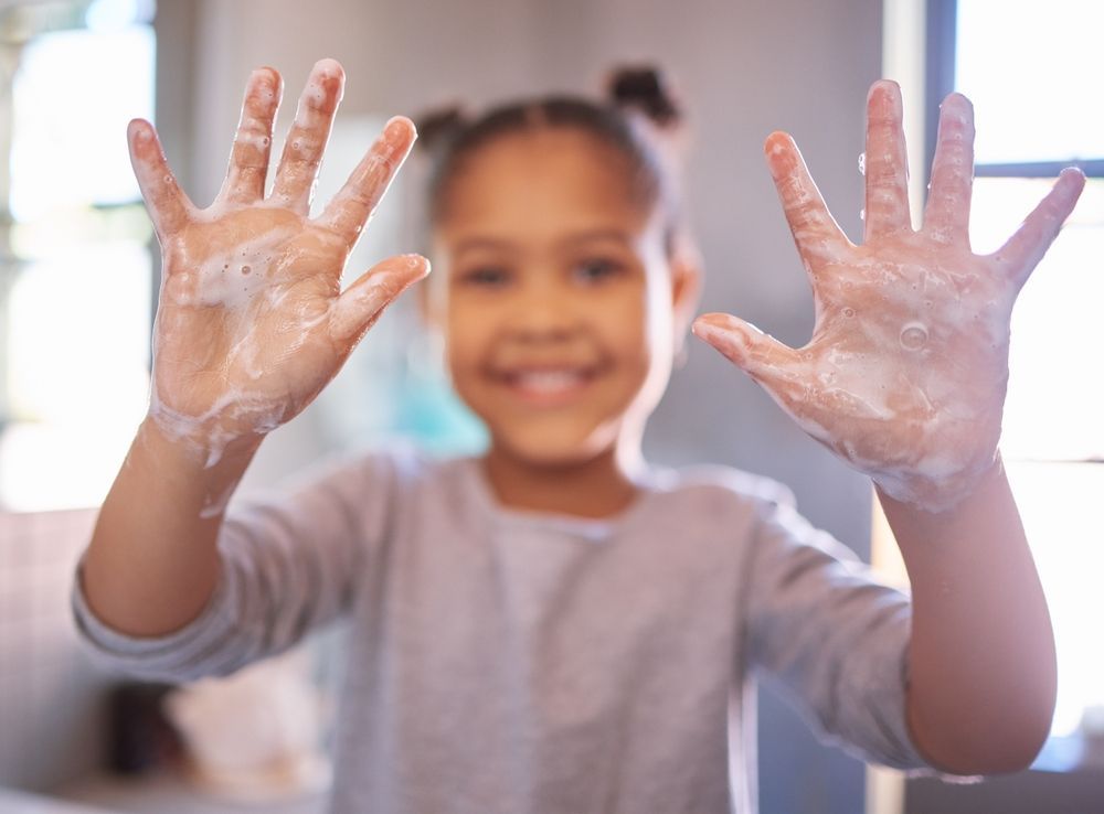 preschooler washing her hands as part practical Montessori life activities