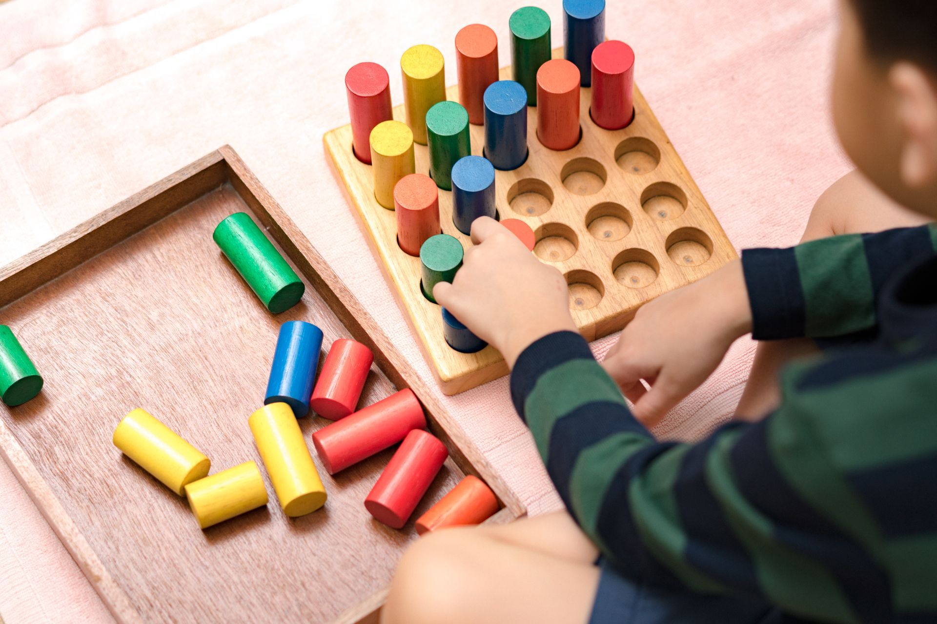 A child is playing with a Montessori activity.