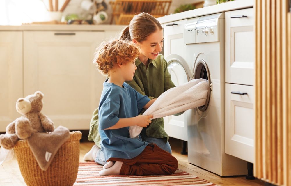 A kid helping his mom with laundry, a popular montessori life activity.