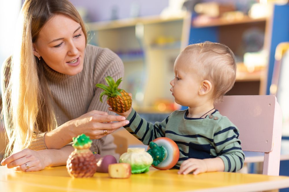 A woman is holding a pineapple next to a baby.