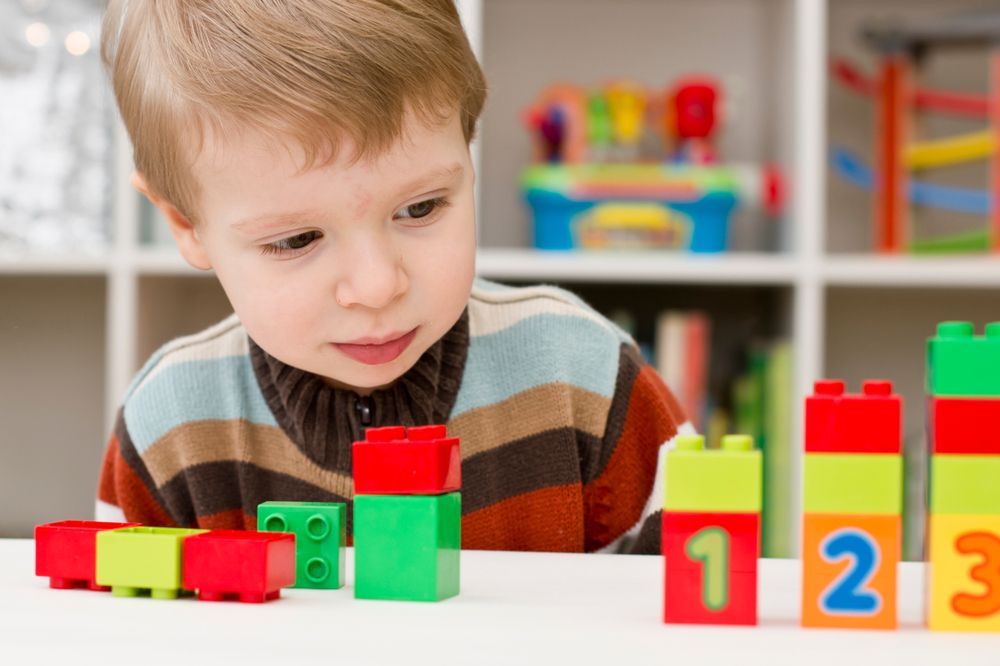 child learning to count using one-to-one correspondence at a Montessori