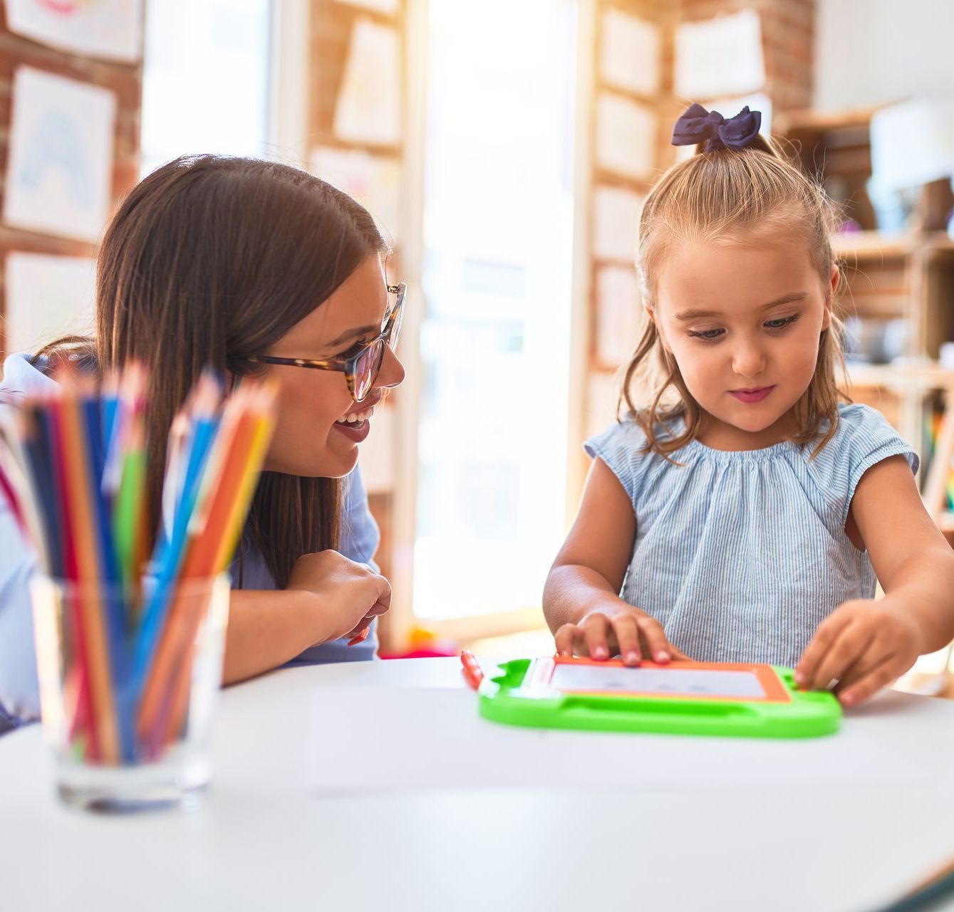 A Montessori teacher and a young child are building a foundation for future learning through preschool activities.