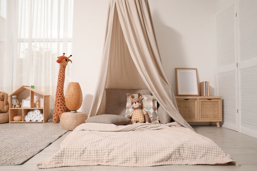 A bedroom with a canopy over a bed and stuffed animals.