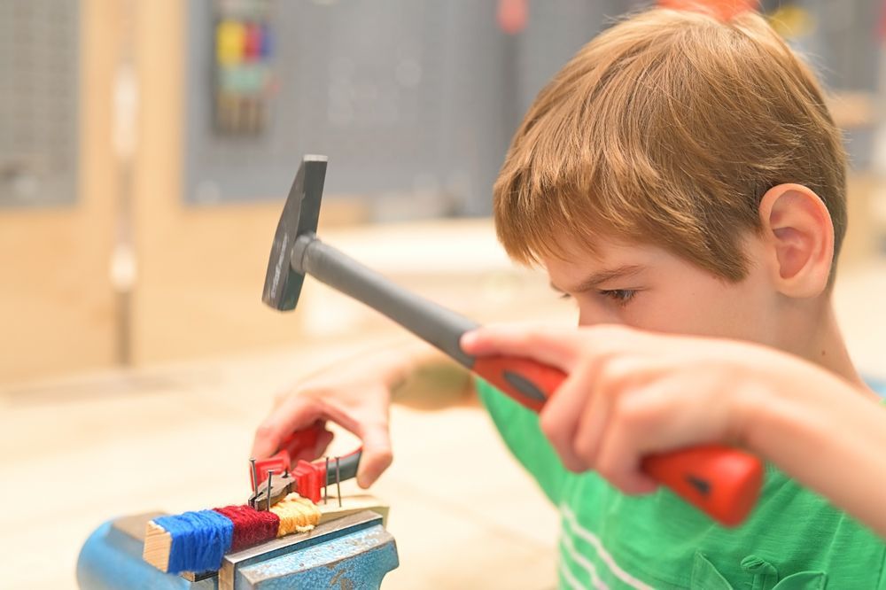 preschooler using toy hammer and nails as part of Montessori practical life activities