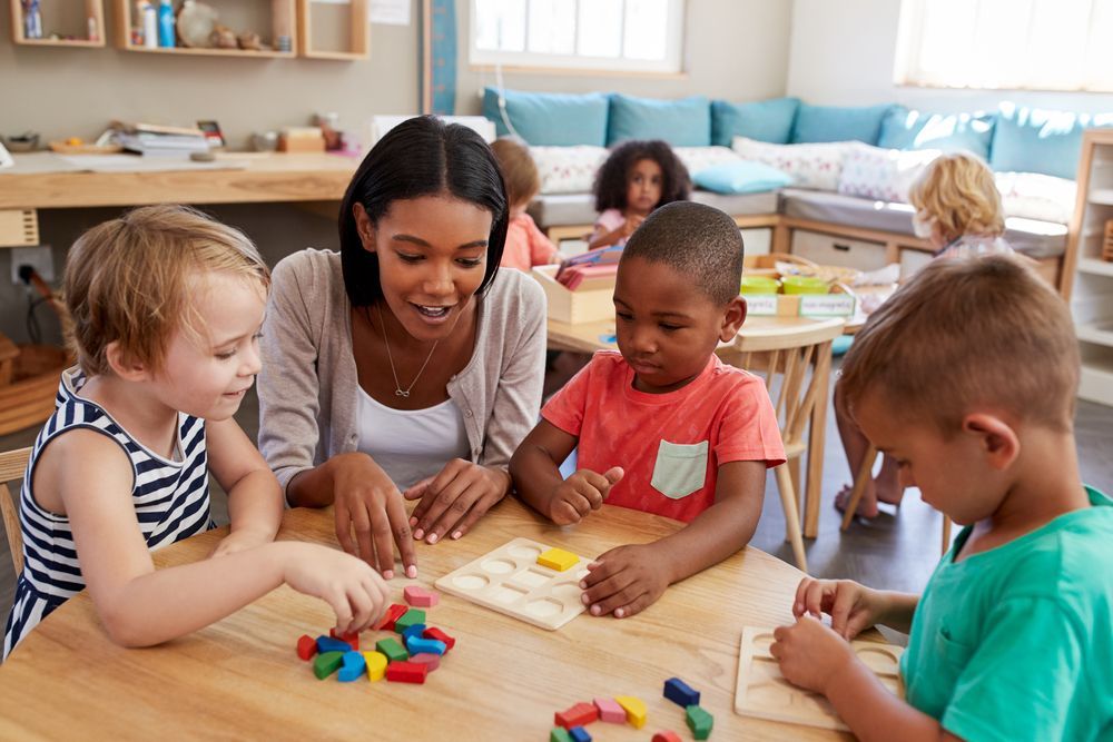 Montessori teacher developing an understanding of shapes with young students using manipulatives