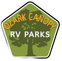 Logo for Ozark Canopy RV Parks: A pentagonal green sign with a central tree silhouette and orange and white text.