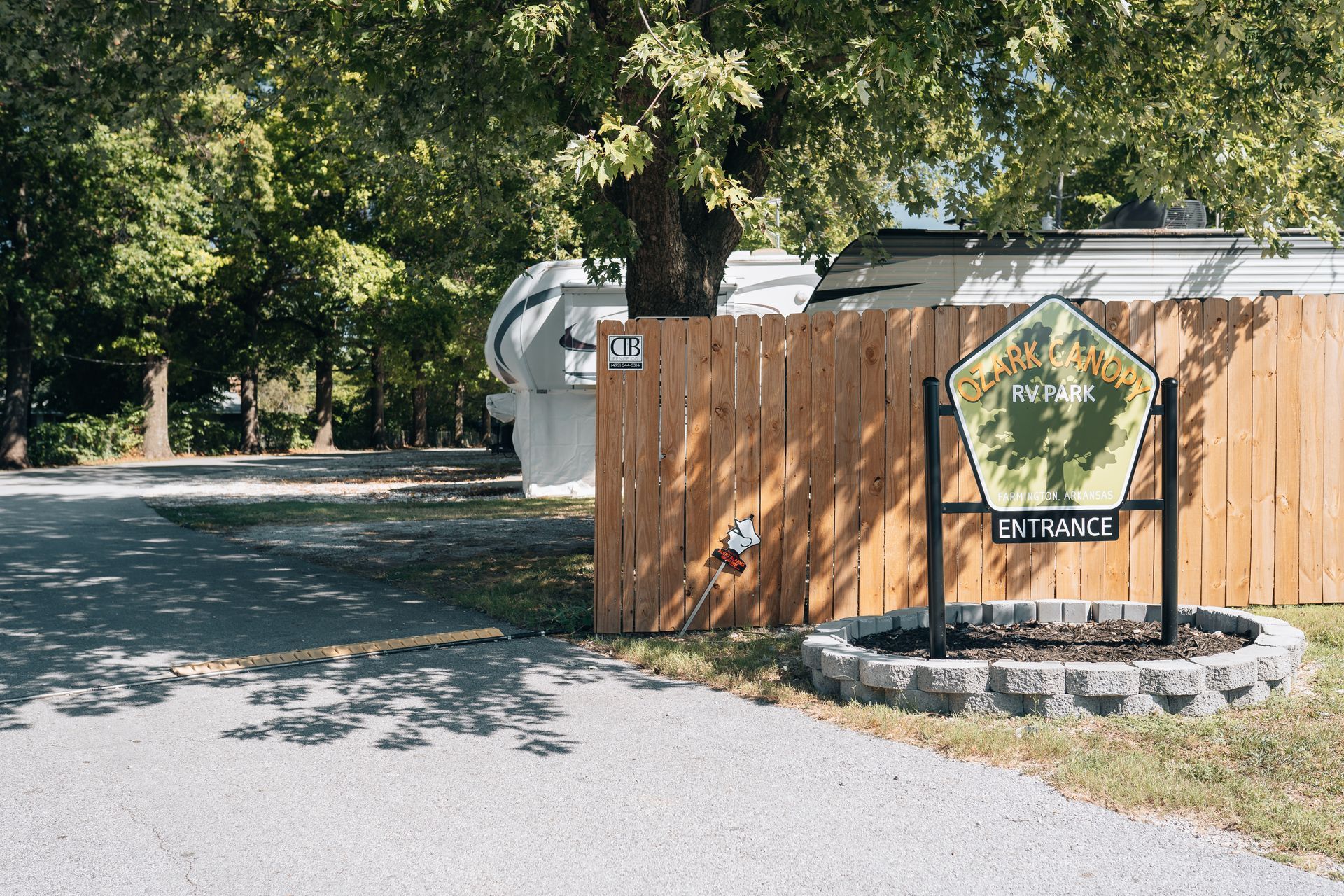 A wooden fence and a stone-bordered sign reading 