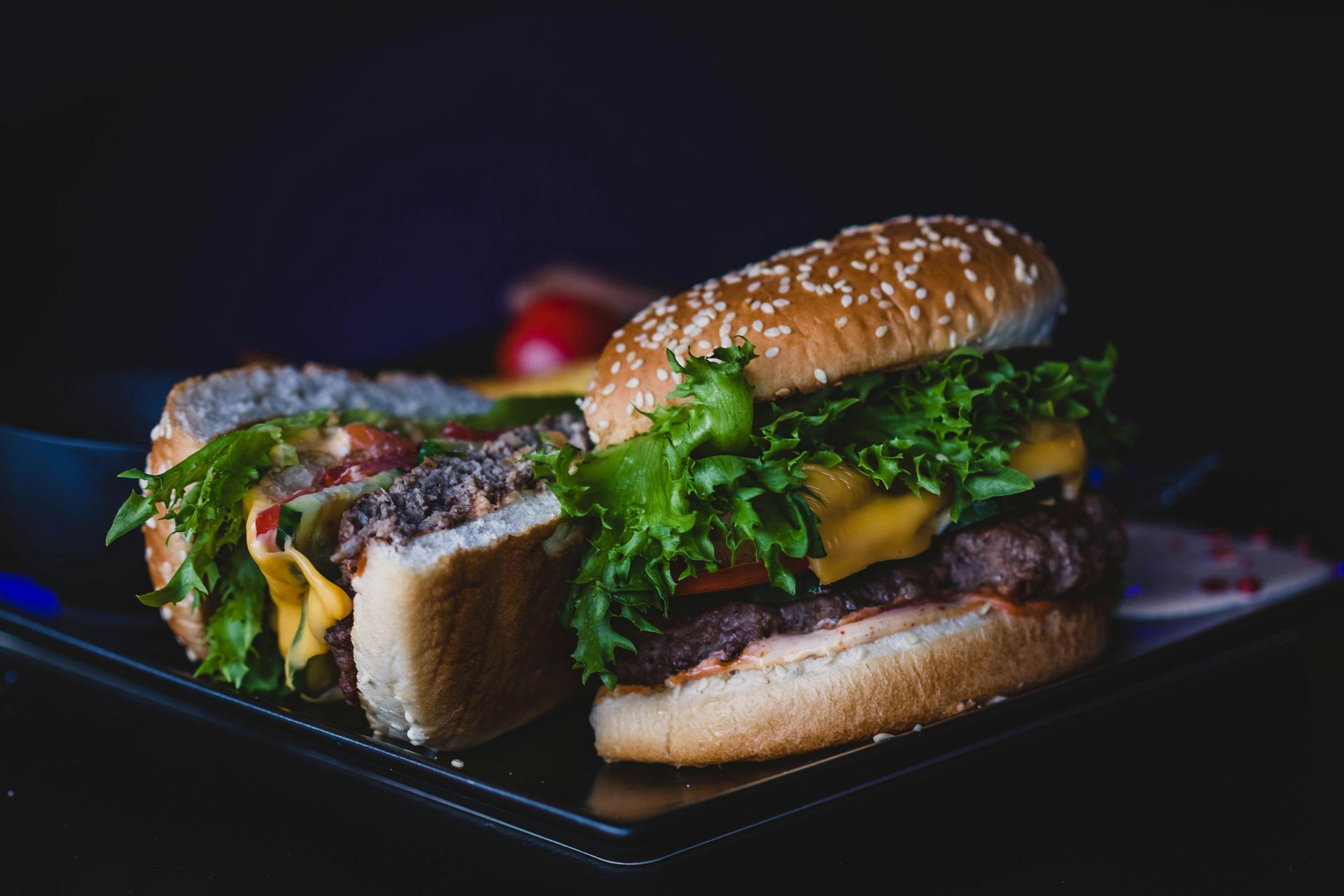 A close up of a hamburger on a plate on a table.