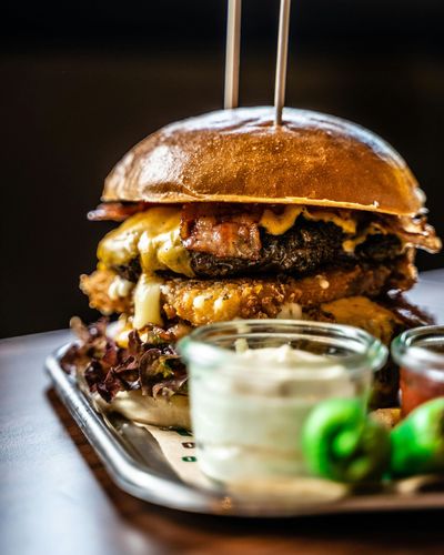 A close up of a hamburger on a tray on a table.