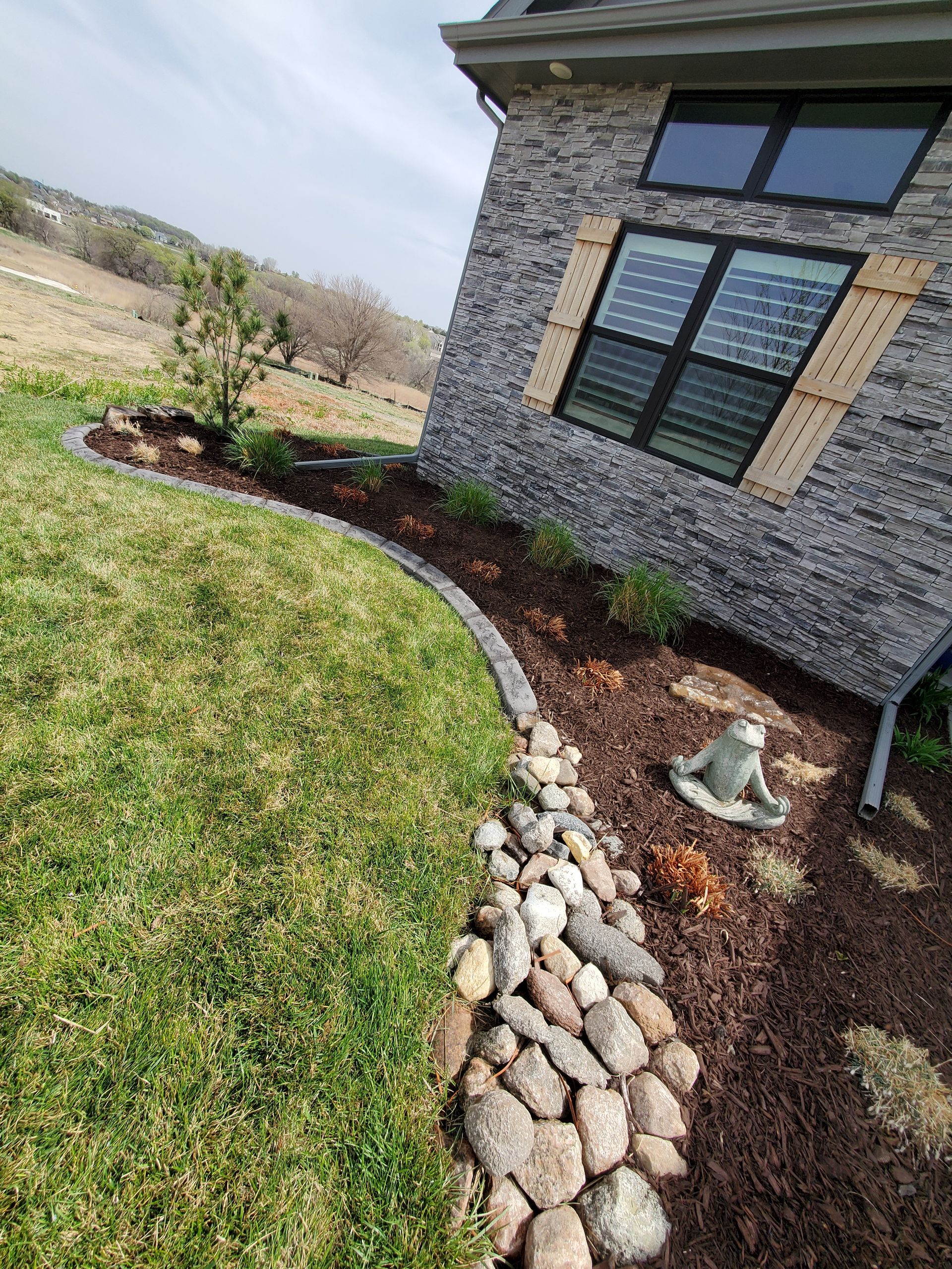 There is a statue of a monkey in the yard next to a house.