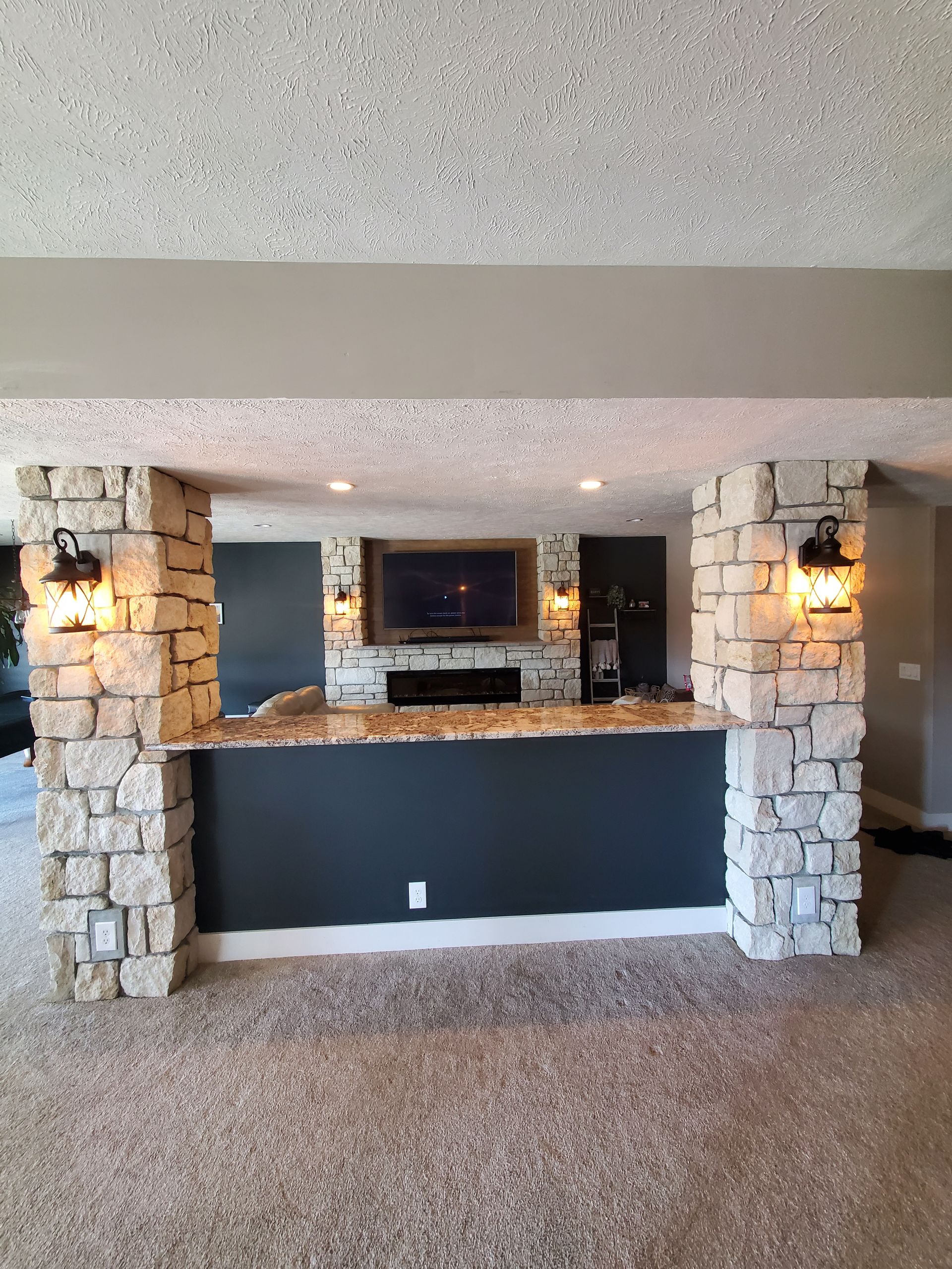 A living room with a stone wall and a bar