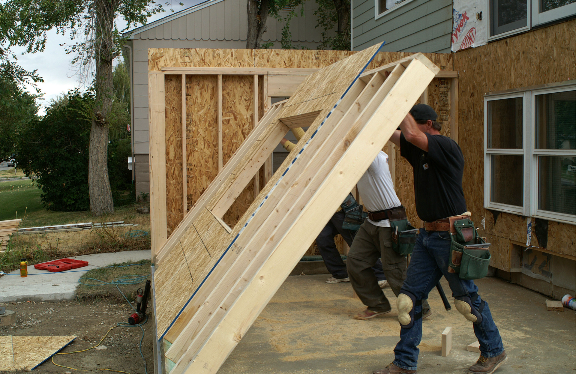 A group of men are carrying a large piece of wood.