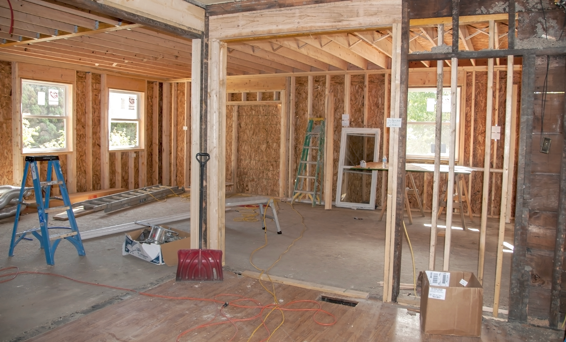 A room that is being built with a ladder and a box on the floor