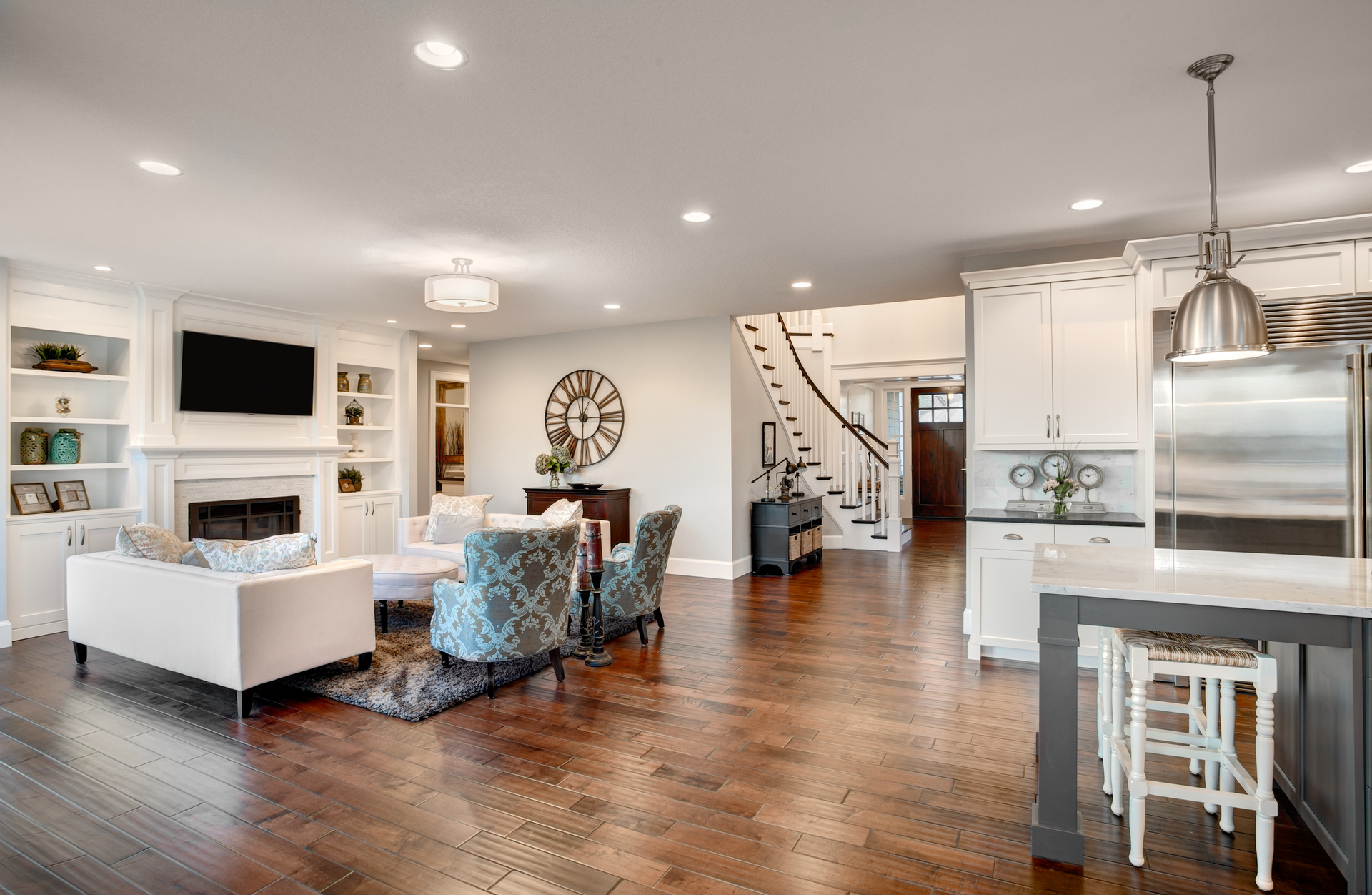 A living room and kitchen in a house with hardwood floors.
