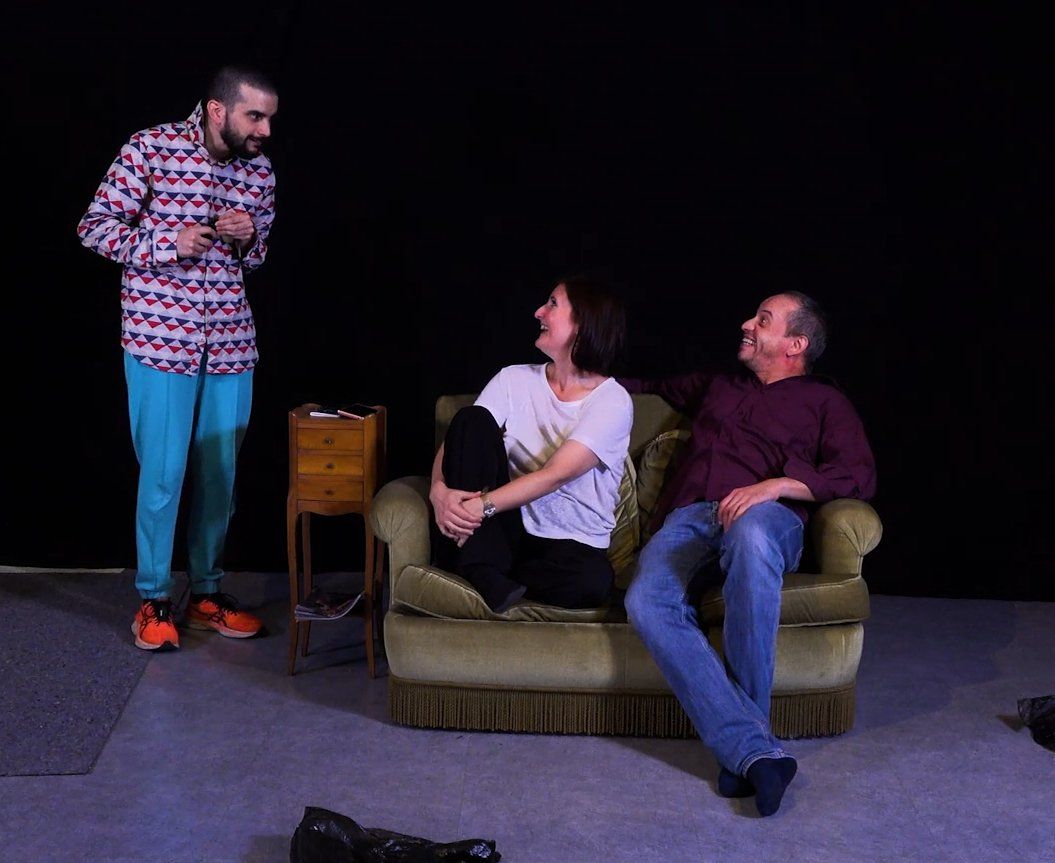 un homme et une femme sont assis sur un canapé et se parlent.