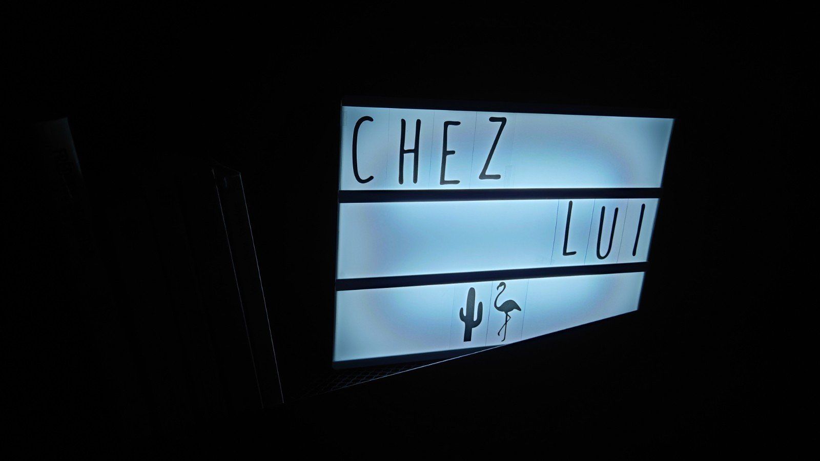 un panneau indiquant chez lui est allumé dans le noir