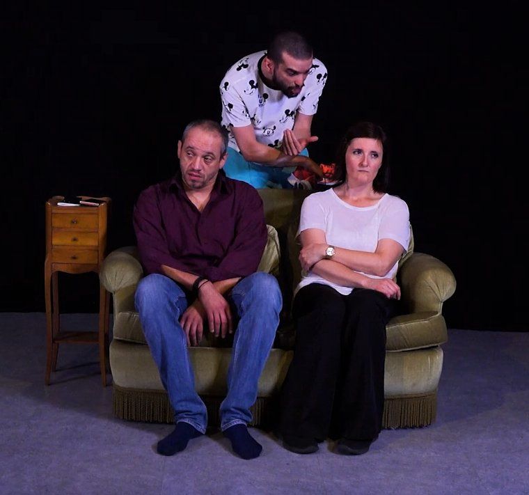 deux hommes et une femme sont assis sur un canapé