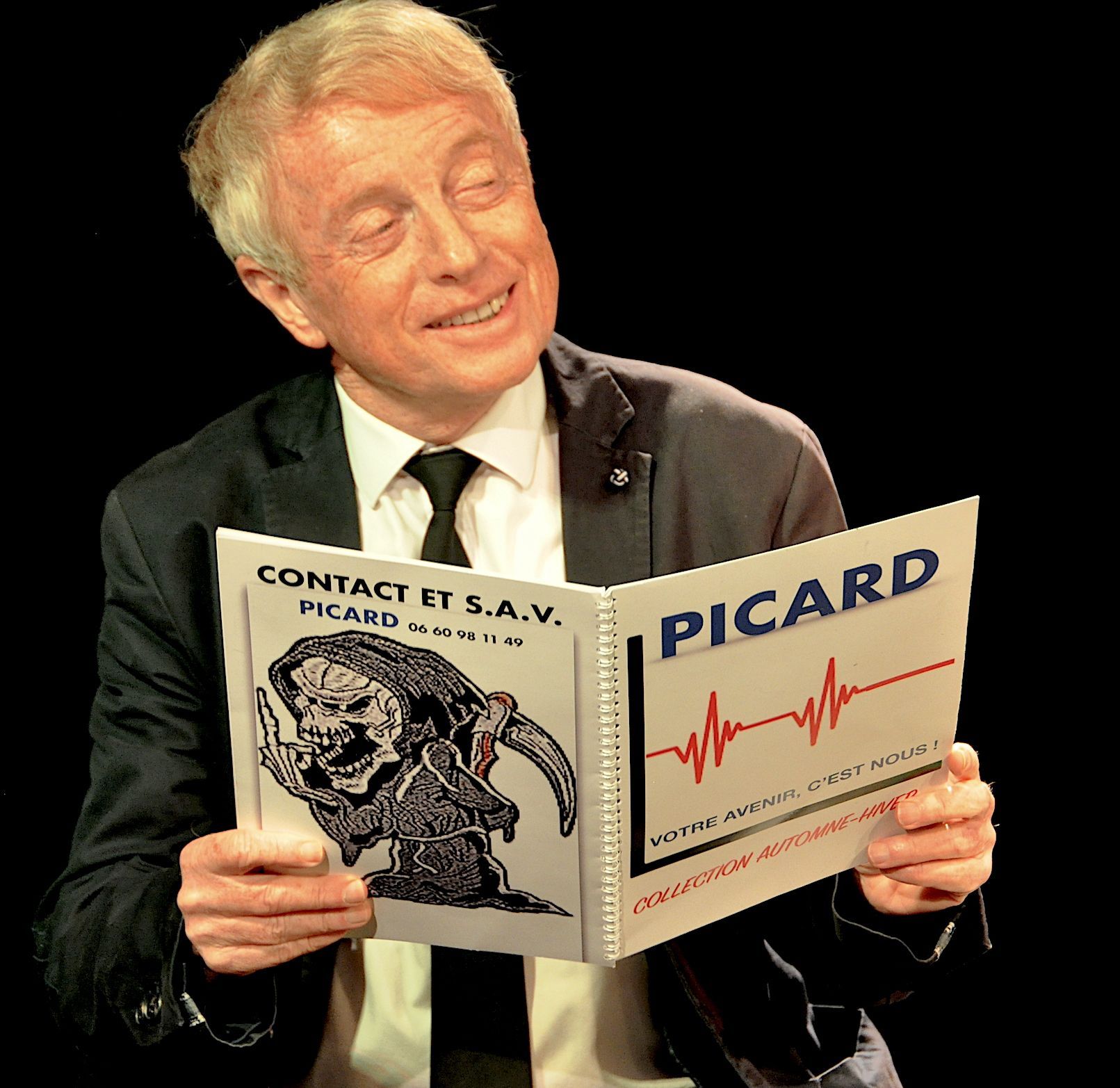 Un homme en costume et cravate lit un livre picard