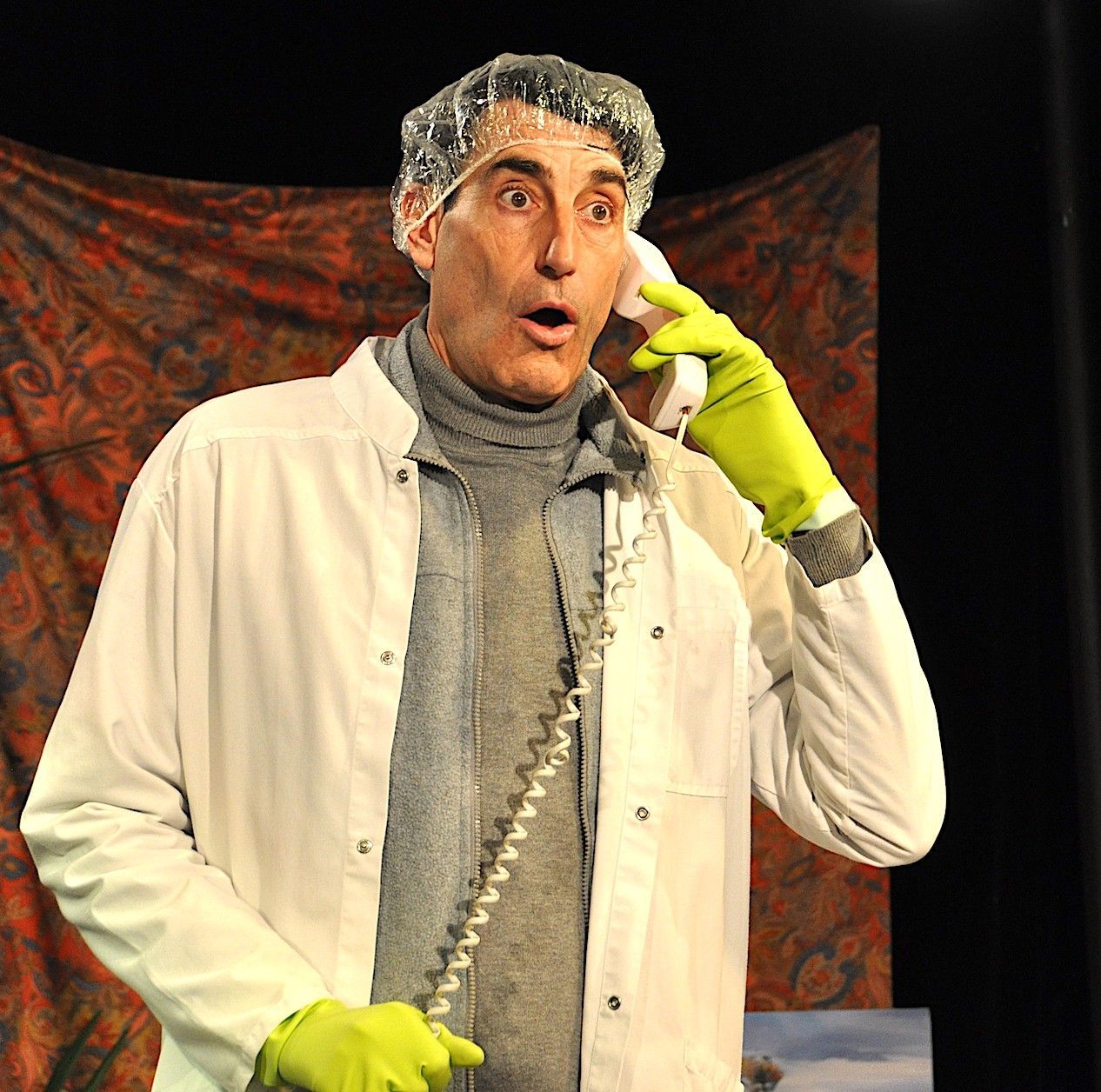 Un homme portant des gants verts parle au téléphone