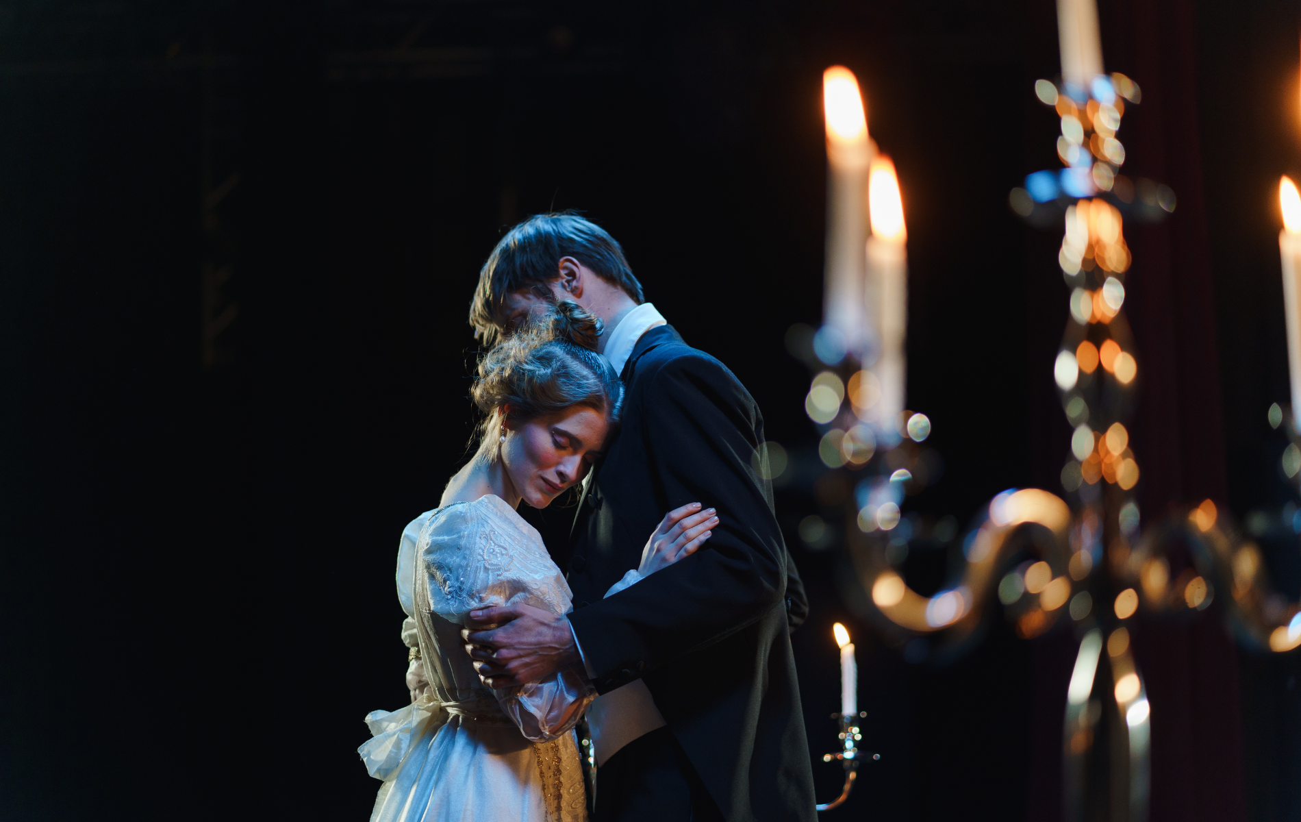 un homme et une femme dansent devant des bougies