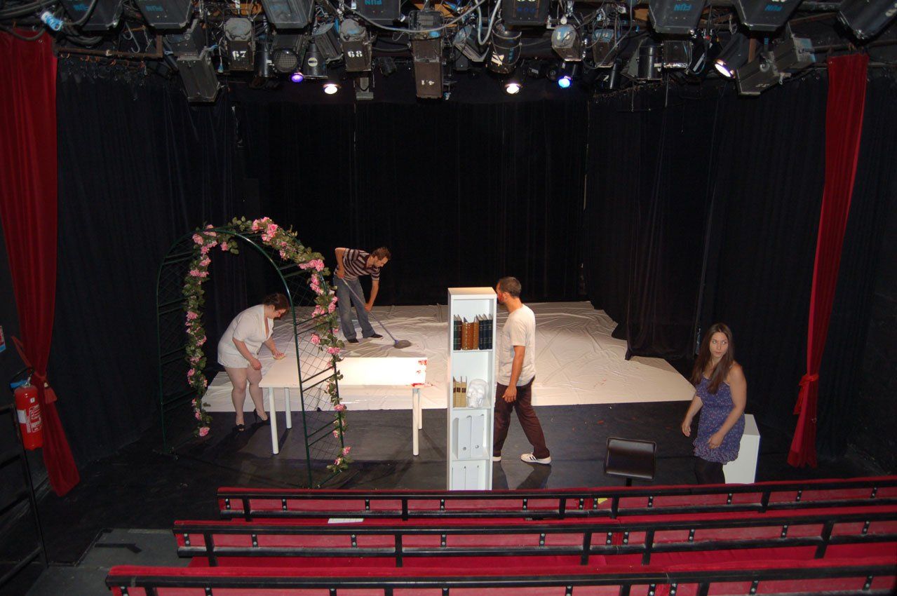 un groupe de personnes se tient sur une scène dans un théâtre.